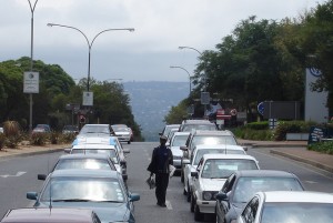 Man Selling Newspapers In Traffic